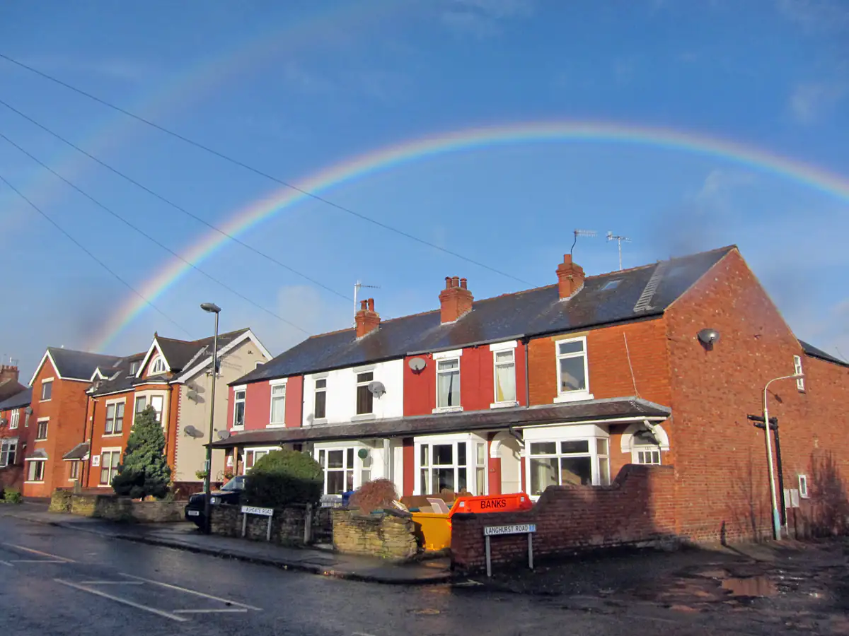 Red-brick terraced houses in Ashgate, Chesterfield, under a rainbow