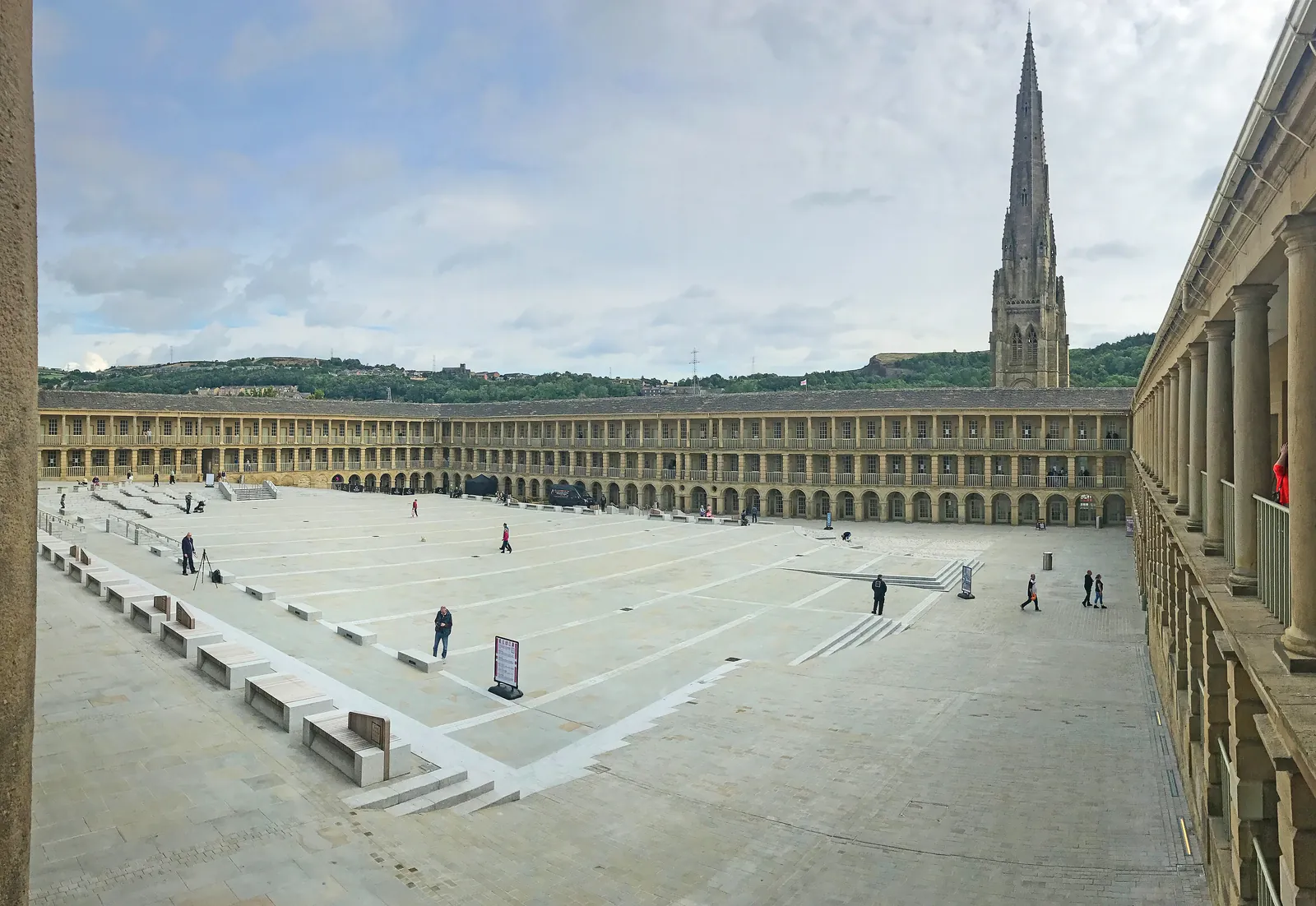 The colonnaded courtyard of the Piece Hall in Halifax, with a church spire beyond