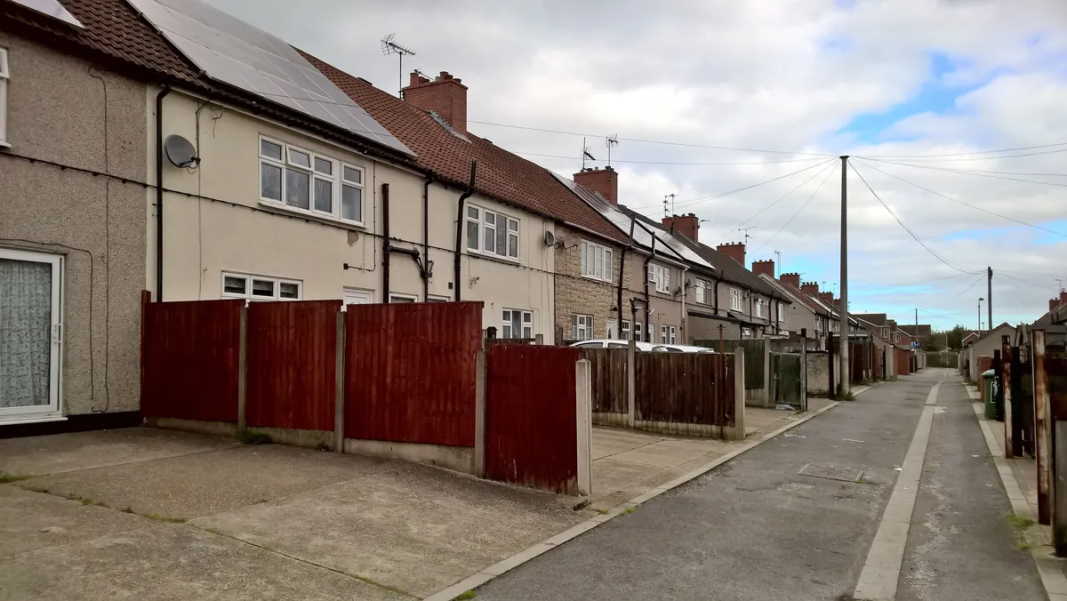A row of rendered terraced houses with driveways along one of the avenues in Forest Town, Mansfield